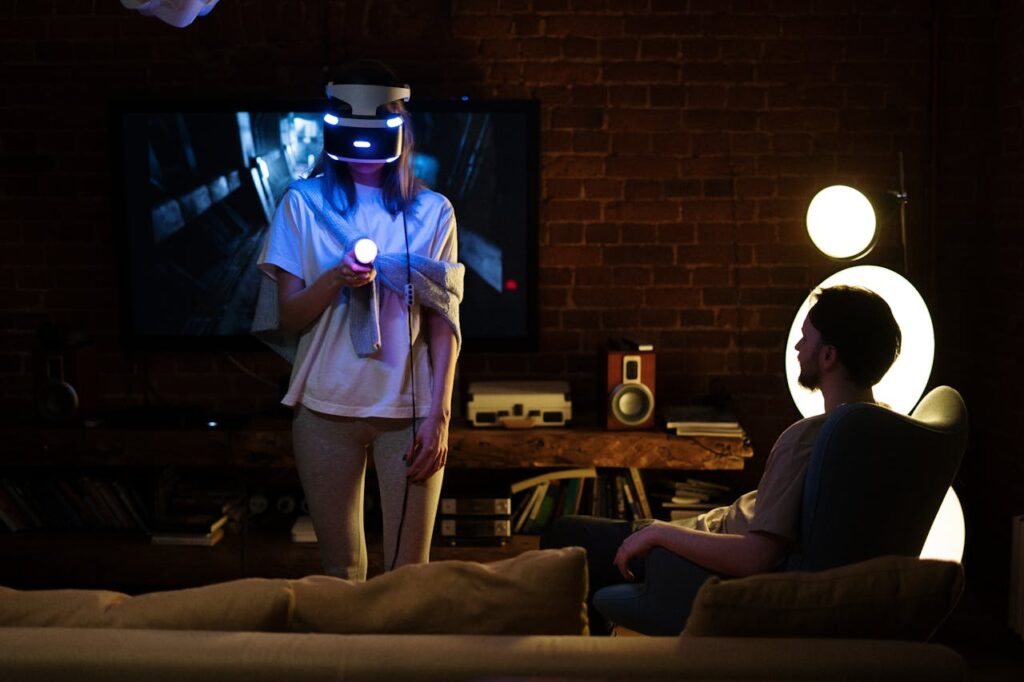 A couple enjoys virtual reality gaming at home, surrounded by cozy decor at night.